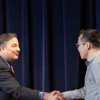 James Nguyen shaking hands with Dr. Smart.